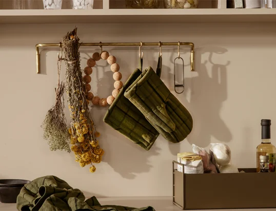 Die Hale Ofenhandschuhe von ferm Living in der Ambienteansicht: Die gemusterten Handschuhe schützen die Finger stilvoll vor heißen Töpfen und Pfannen und können einfach an der Schlaufe aufgehangen werden.