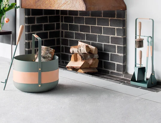 Der Holzkorb Emma von Eldvarm in der Ambienteansicht: Der Feuerholzkorb aus pulverbeschichtetem Metall und Leder wird zum absoluten Hingucker am Kamin.