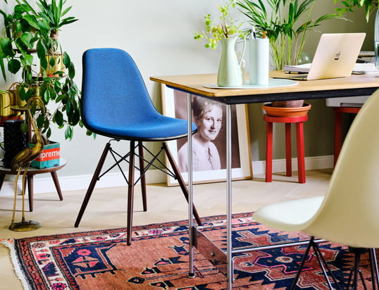 Der Eames Plastic Side Chair DSW von Vitra in der Ambienteansicht: Der filigrane Stuhl wird durch das leuchtende Blau zum absoluten Hingucker im Wohnzimmer.
