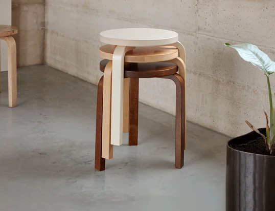 Der Hocker 60 von Artek in der Ambienteansicht: Der dreibeinige Hocker kann gestapelt und durch sein schlichtes Äußeres überall im Raum platziert werden.