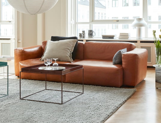 Das Mags Soft Sofa von Hay in der Ambienteansicht: Das hochwertige Ledersofa in Cognac lässt sich perfekt mit beigen Kissen und einem grauen Teppich kombinieren.
