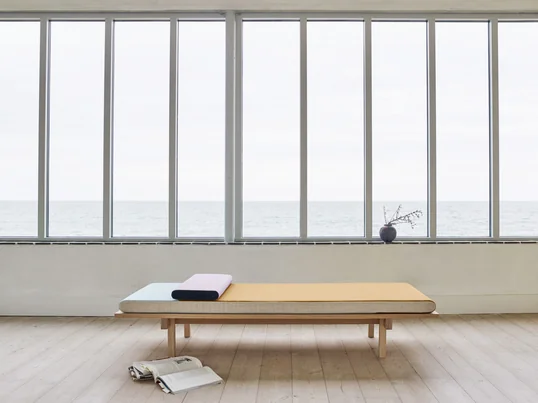 Die Tagesbett-Liege aus Kiefern-Holz und Wolle bietet ausreichend Platz zum Verweilen oder den Mittagsschlaf. Das Daybed passt dank der minimalistischen Form zu jedem Stil.