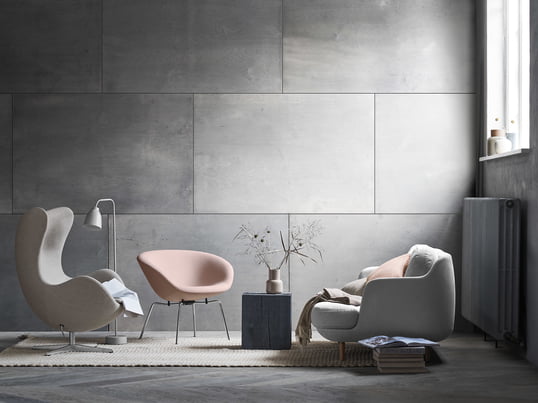 Das gemütliche Lune 2-Sitzer Sofa von Fritz Hansen mit dem passenden Pot Sessel in soften Grau und Rose-Tönen. Ein modernes Wohnzimmer-Ambiente vor grauer Wand.