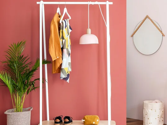 Der Lucien Garderobenständer besteht aus einem Metallrohrgestell, das in verschiedenen matten Lackierungen erhältlich ist. Die untere Ablage für Schuhe, Taschen und Ähnliches besteht aus massivem Eichenholz.