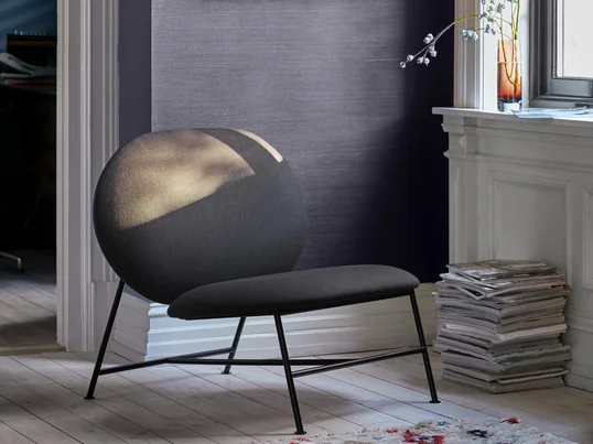 Der Northern - Oblong Lounge Chair in der Ambienteansicht. Minimalistisch gestaltet mit einem schmalen Untergestell aus Stahl und zwei großzügigen, ovalen Kaltschaum-Polstern für die Sitzfläche sowie die Rückenlehne, fügt sich der niedrige Lounge Sessel bestens in jede Einrichtung ein, ohne dabei aufdringlich zu wirken.
