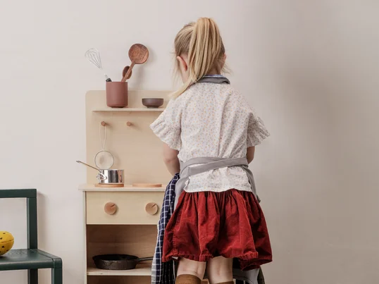 Toro Spielküche in Buche von Ferm Living in der Einzelansicht. Die Küche verfügt über ein Waschbecken inklusive Wasserhahn, zwei Herdplatten, drei Haken sowie Regalen zur Aufbewahrung.