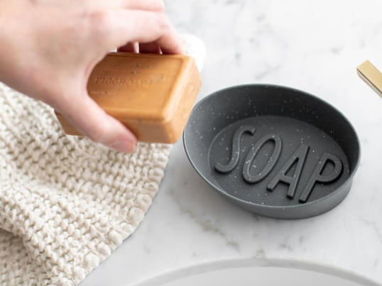 Mit dem Statement SOAP verlangt die dekorative Soap Seifenschale nach einem duftenden Stück Seife. Hergestellt aus recyceltem Kunststoff, ist die Schale von Koziol nicht nur dekorativ, sondern auch umweltbewusst.