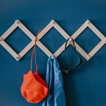 Die Lia Wandgarderobe von side by side an einer blauen Wand mit Schwimmsachen