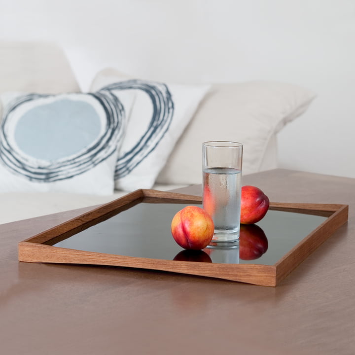 Das Tablett Turning Tray mit einem Glas neben dem Sofa