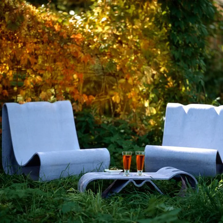 Der Willy Guhl Loop Outdoor-Sessel und der Tisch von Eternit im herbstlichen Garten