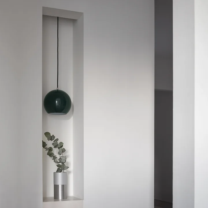 Die Topan Pendelleuchte VP6 von &Tradition in schwarz in einer Einlassung in der Wand über einer Vase