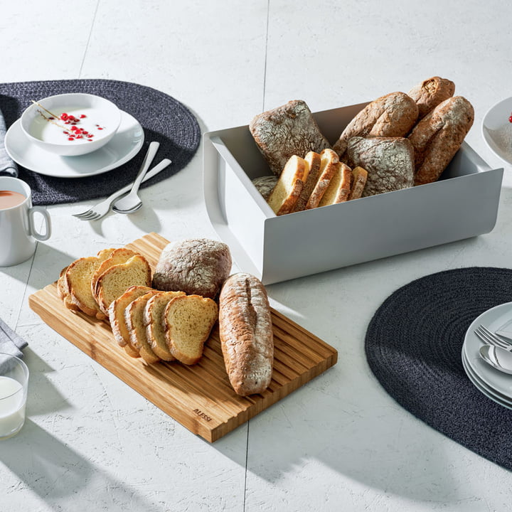 Der Mattina Brotkasten mit Schneidebrett von Alessi auf dem gedeckten Frühstückstisch