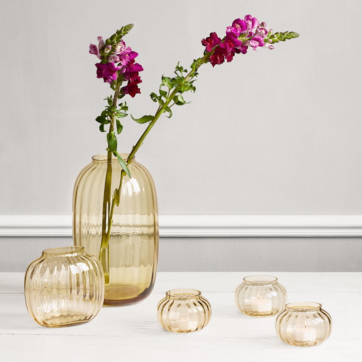 Die Primula Teelichthalter, Ø 9,5 cm, amber neben der Primula Vase von Holmegaard auf dem Tisch