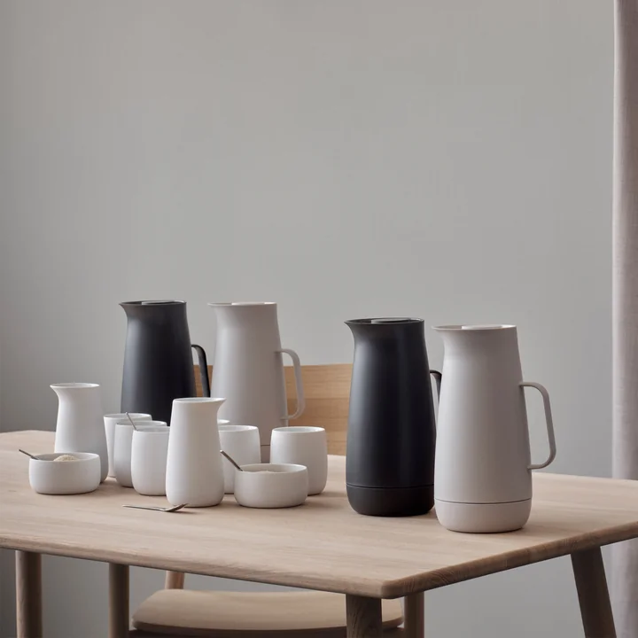 Die Foster Isolierkanne von Stelton in ihren verschiedenen Ausführungen mit Schalen und Kannen auf dem Tisch