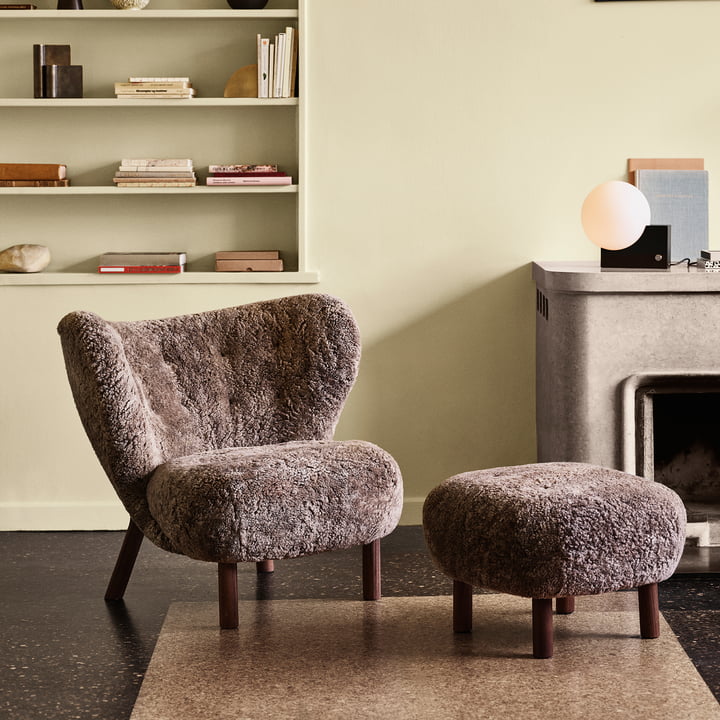 Der Pouf ATD1 in der Farbe Sheep Sahara neben dem Little Petra Lounge Chair von &Tradition im Wohnzimmer