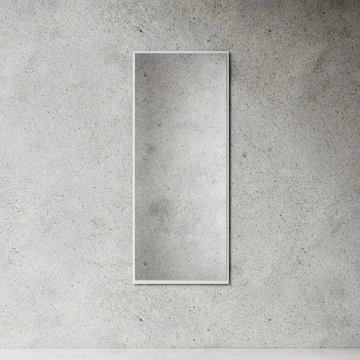 Der große Wandspiegel von Nichba Design in weiß an einer Steinwand