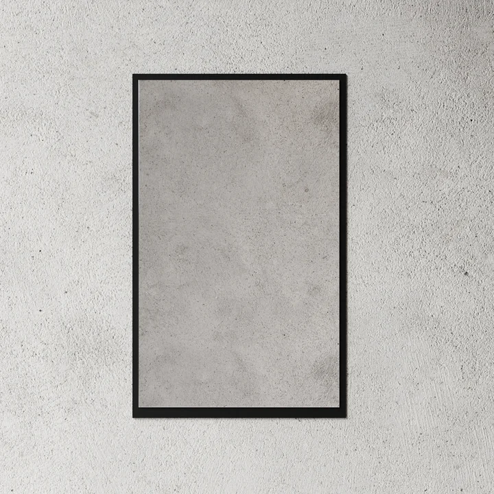 Der kleine Wandspiegel von Nichba Design in schwarz an eine rSteinwand