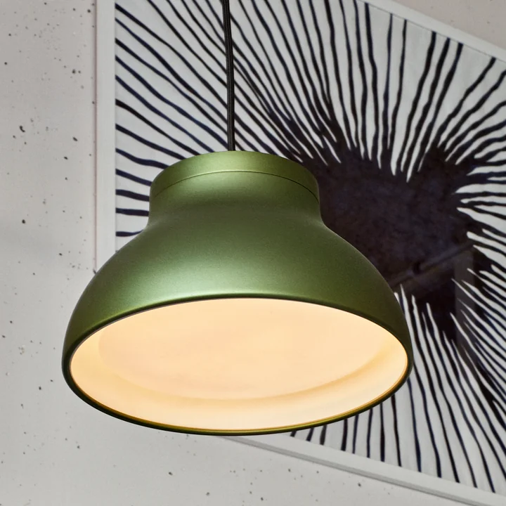 Die PC Pendelleuchte von HAY in emerald green vor einem schwarz-weißen Kunstwerk
