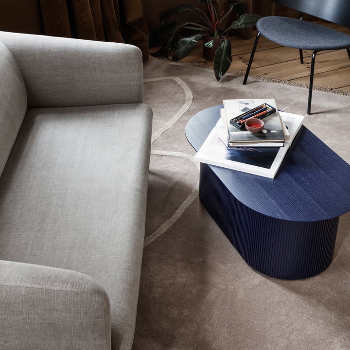 Das Turn Sofa (3-Sitzer) von ferm Living in Leinen natur vor einem blauen Holz-Beistelltisch