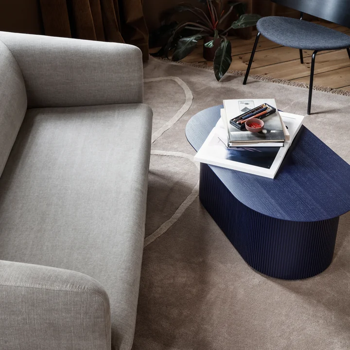 Das Turn Sofa (3-Sitzer) von Ferm Living in Leinen natur vor einem blauen Holz-Beistelltisch