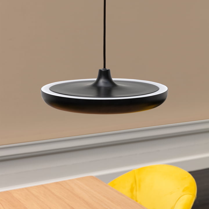 Die Cassini LED-Pendelleuchte Medium von Umage in schwarz über einem Holz-Tisch mit gelbem Stuhl