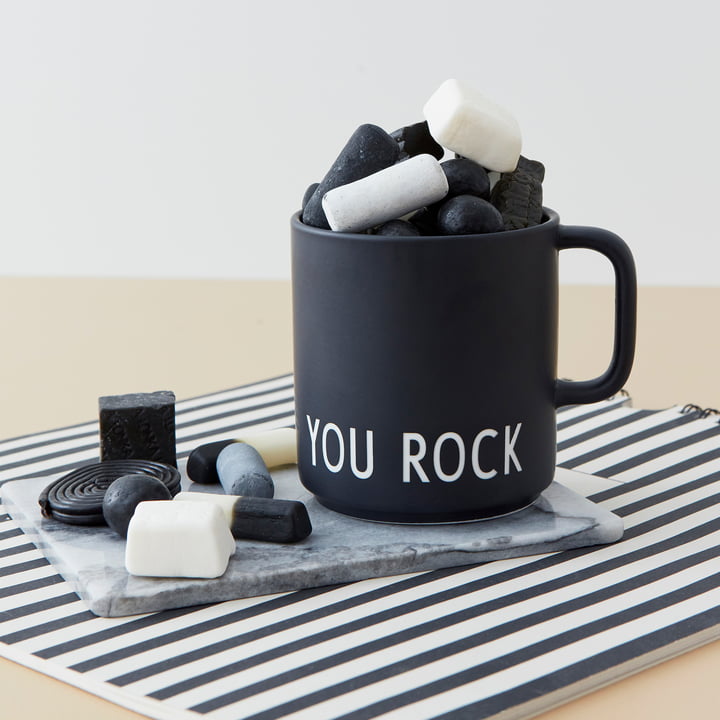 Der AJ Favourite Porzellan Becher von Design Letters in You Rock /schwarz gefüllt mit schwarz-weißen Süßigkeiten