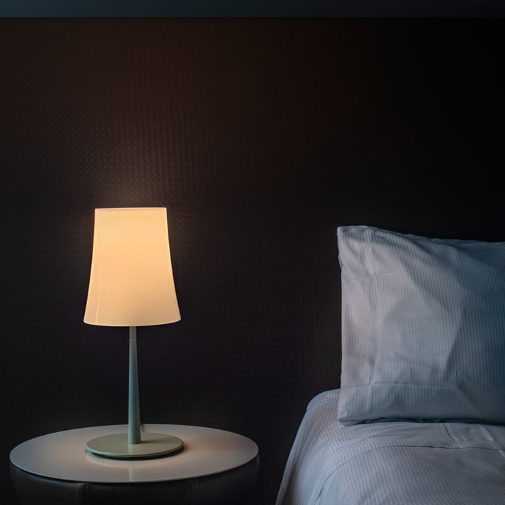 Die Birdie Easy Tischleuchte von Foscarini auf einem Nachttisch neben dem Bett