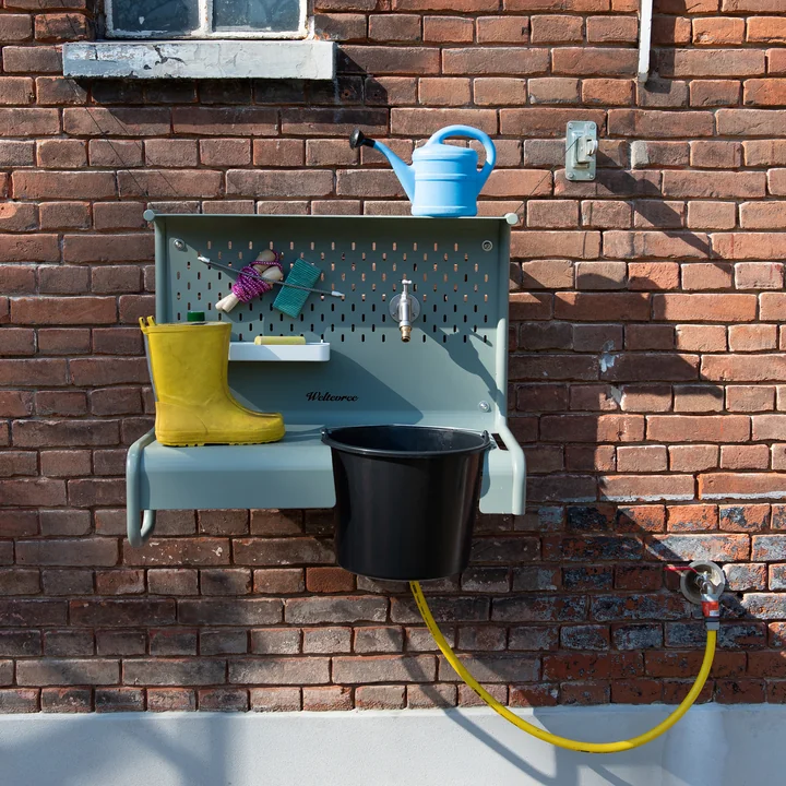 Der Waterworks Ablagetisch von Weltevree mit Gummistiefeln, Kreide und Spielzeug