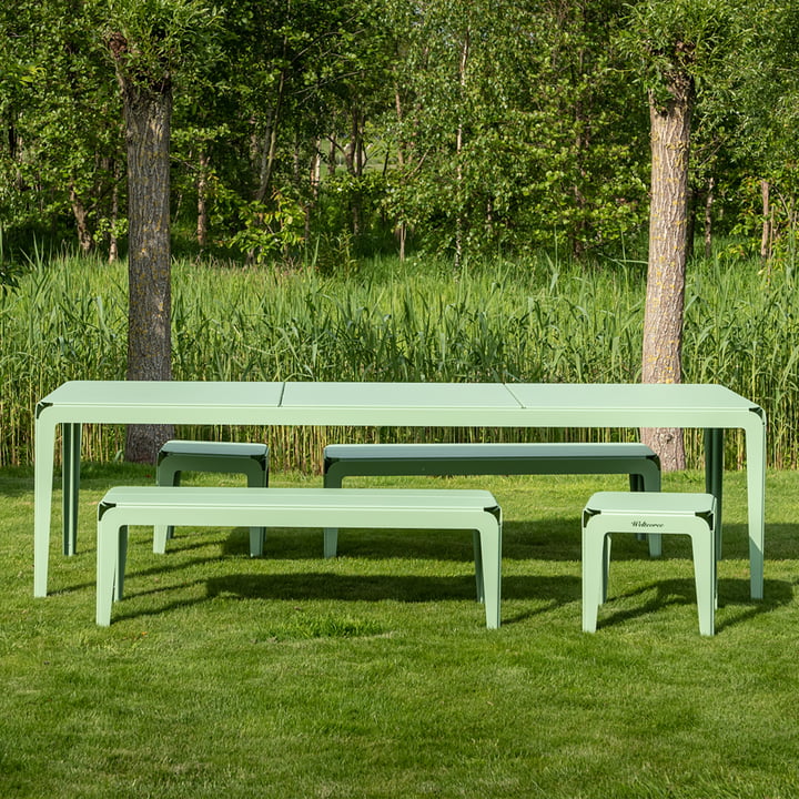 Die Bended Bench Bank und der Bended Tisch von Weltevree auf einer grünen Wiese