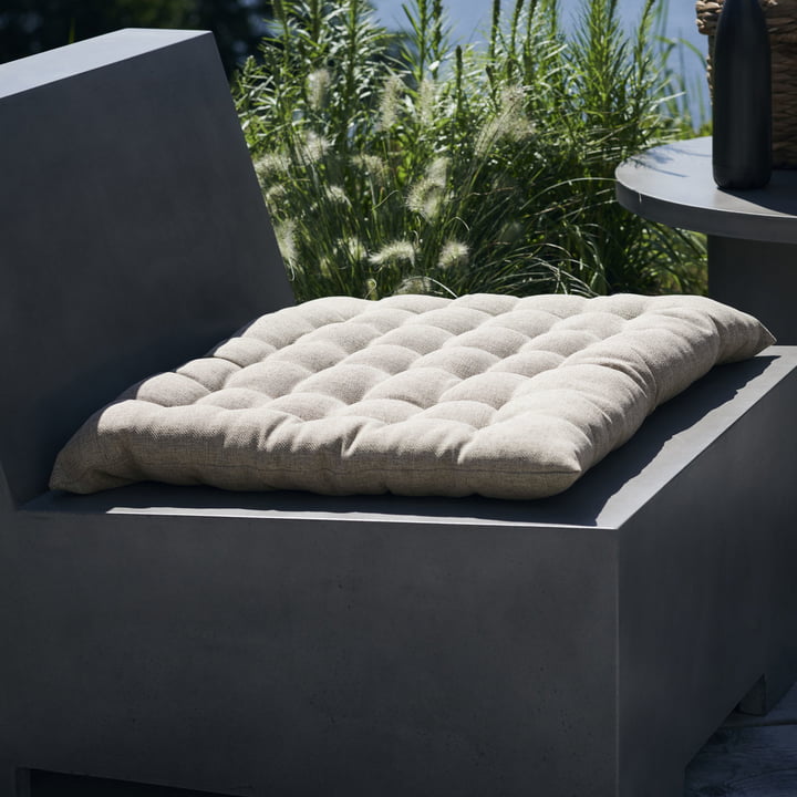 Das Fine Outdoorkissen von House Doctor auf einem Beton-Loungesessel