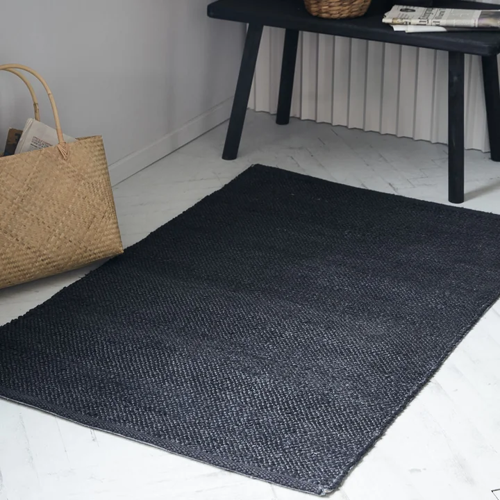 Der schwarze Hempi Teppich von House Doctor vor einer Bank