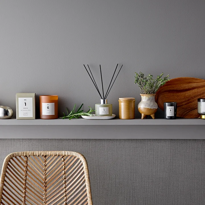 Die ILLUME Duftkerze von Bloomingville auf einem Sideboard neben anderen Wohnaccessoires