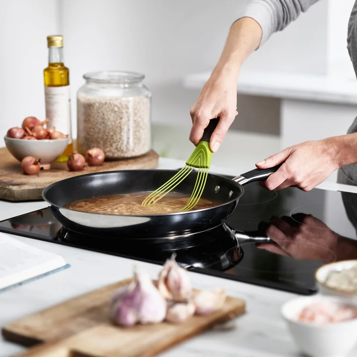 Der flache Twist Schneebesen von Joseph Joseph beim Anrühren einer Soße