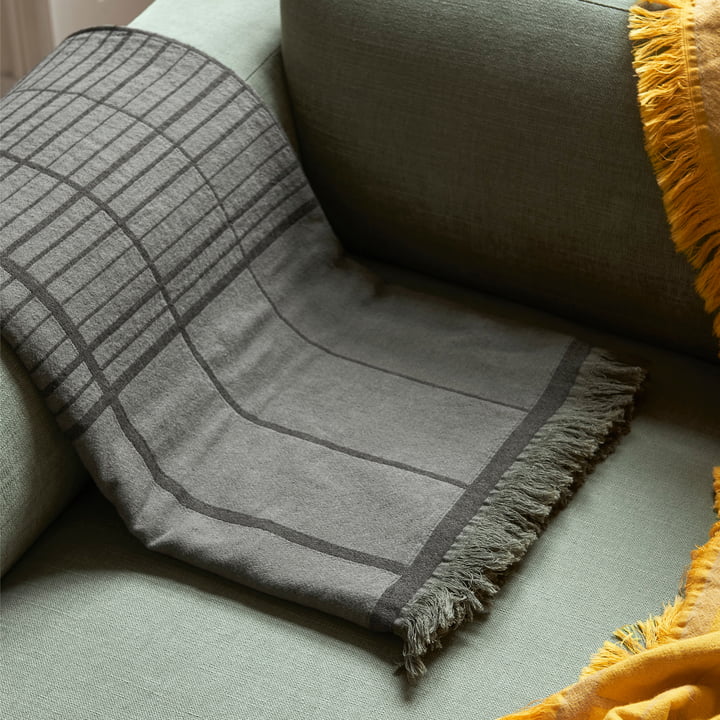 Die Untitled AP10 Tagesdecke von &Tradition kontrastiert mit dem Sofa
