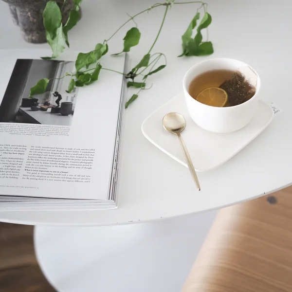Tasse Tee mit goldenem Löffel